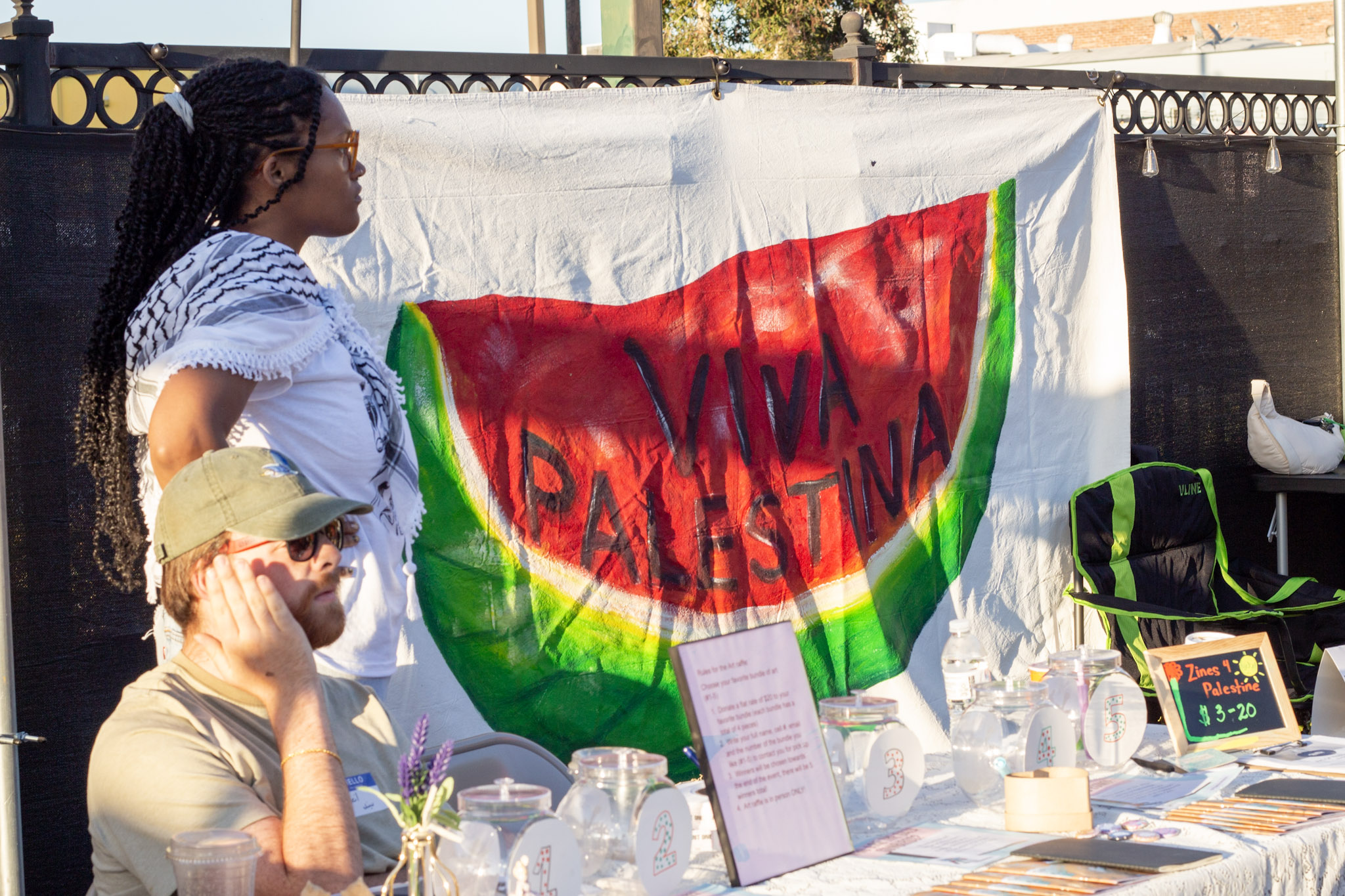 Art of Nothing Press Event Vendor with 'Viva Palestina' banner behind booth
